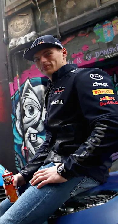 Carousel Slide Image of Max Verstappen and Daniel Ricciardo spray-paint an Aston Martin DB11